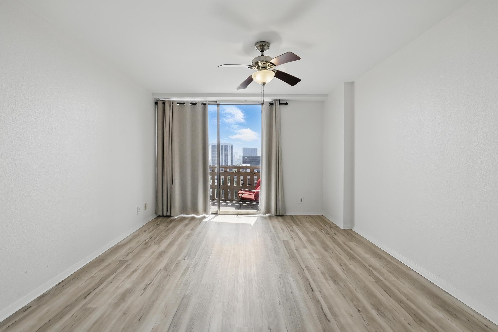 2016 Main Street, Unit 1502 Houston, TX 77002 - Photo 4 of 20 an empty room with wooden floor fan and windows