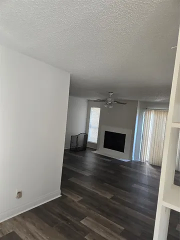 a view of a livingroom with wooden floor and a fireplace