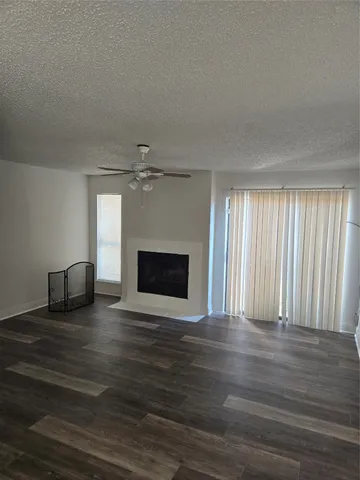a view of empty room with wooden floor and fireplace