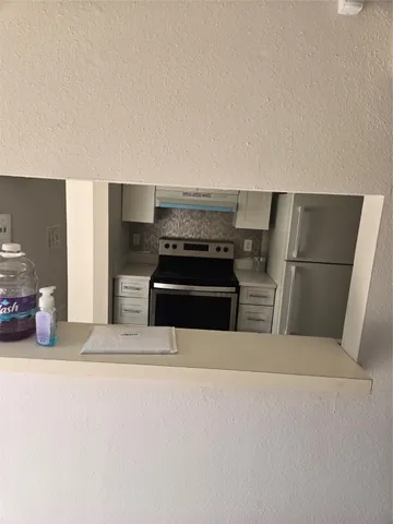 a kitchen with a refrigerator and a stove