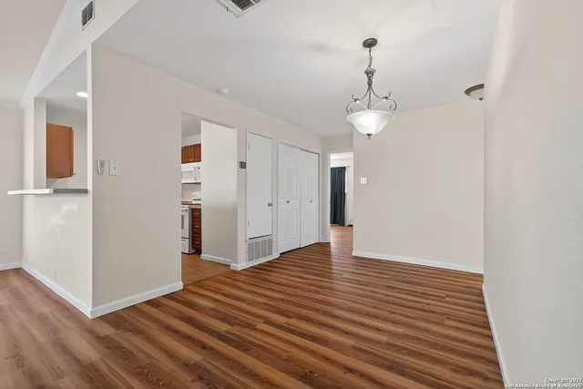 a view of a room with wooden floor and white walls