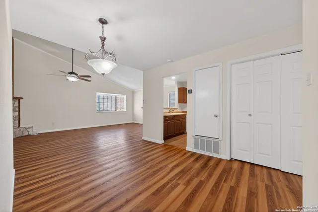 a view of empty room with wooden floor and ceiling fan