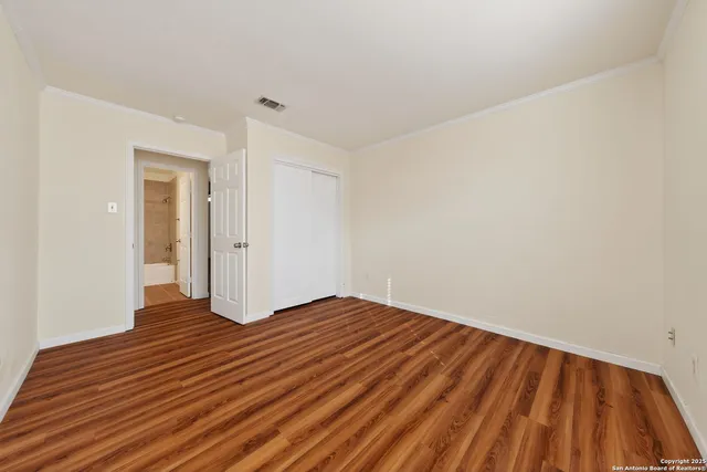 a view of an empty room with wooden floor