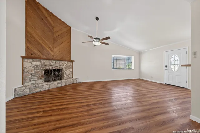 a view of a livingroom with wooden floor and a fireplace