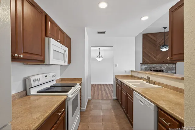 a kitchen with a stove sink and cabinets