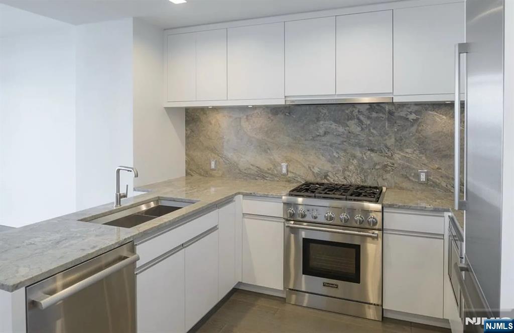 320 Adolphus Avenue, Unit 117 Cliffside Park, NJ 07010 - Photo 5 of 27 a kitchen with granite countertop cabinets stainless steel appliances and a sink