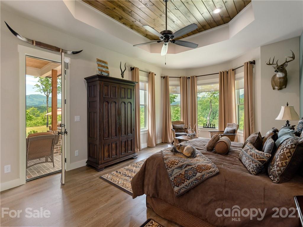 570 Parkway North Rd Mill Spring Mill Spring, NC 28756 - Photo 23 of 48 a spacious bedroom with a large bed and a chandelier