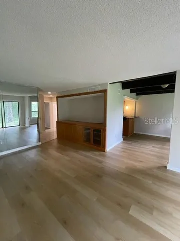 a view of empty room with wooden floor and fireplace