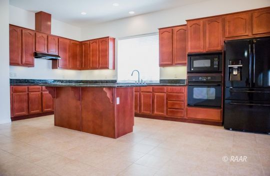 128 West Franklin Avenue Ridgecrest, CA 93555 - Photo 11 of 35 a kitchen with stainless steel appliances granite countertop refrigerator a sink and wooden cabinets