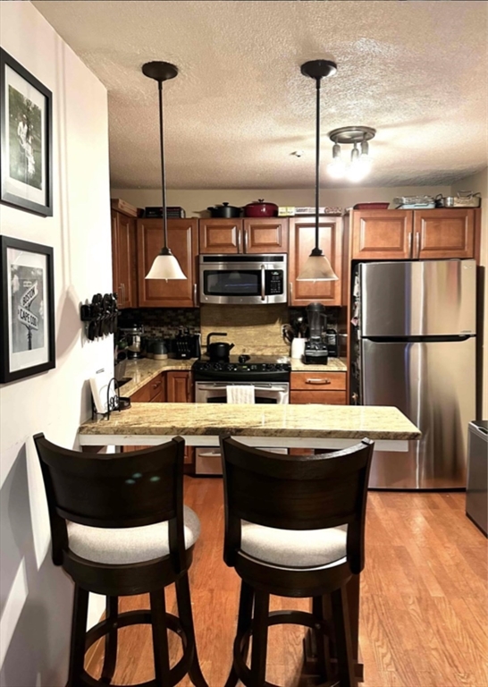 a kitchen with stainless steel appliances granite countertop a sink a stove and chairs