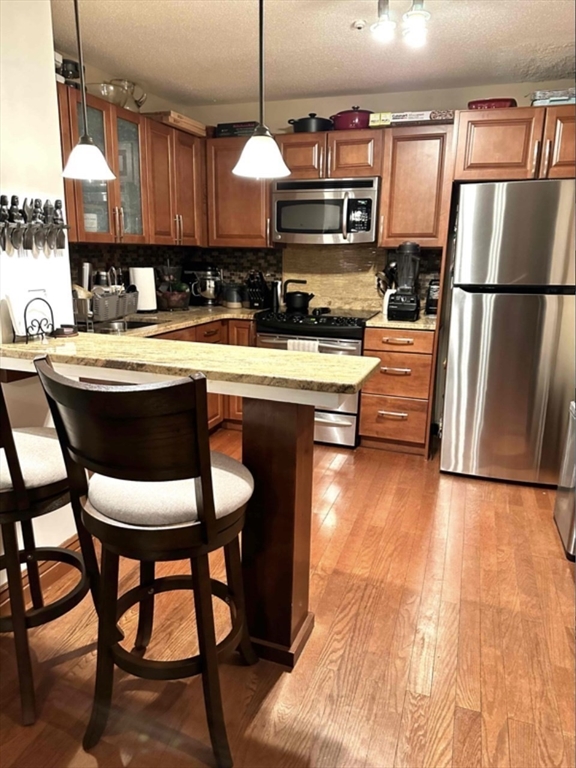 881 Broadway, Unit 9 Chelsea, MA 02150 - Photo 5 of 9 a kitchen with stainless steel appliances granite countertop a sink a stove and a wooden floors