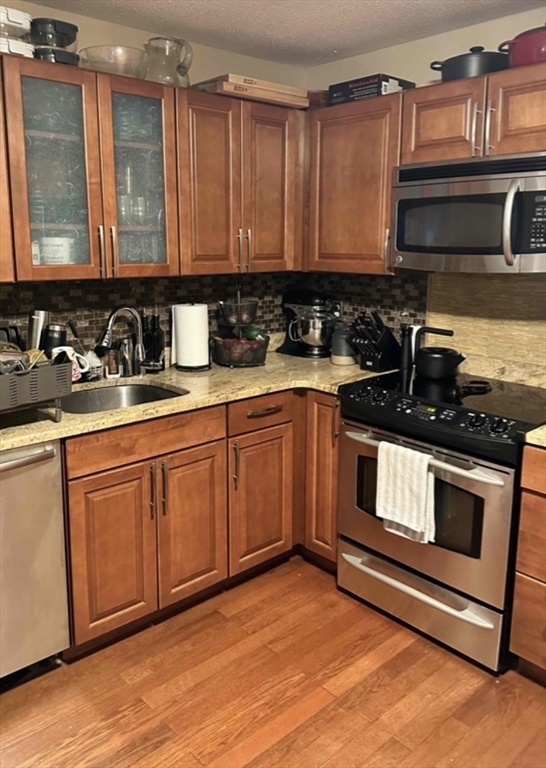 881 Broadway, Unit 9 Chelsea, MA 02150 - Photo 8 of 9 a kitchen with stainless steel appliances granite countertop a stove a sink and a microwave