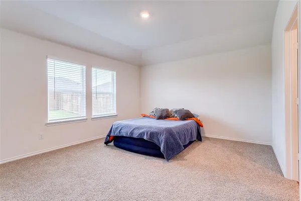 a spacious bedroom with a bed and a window