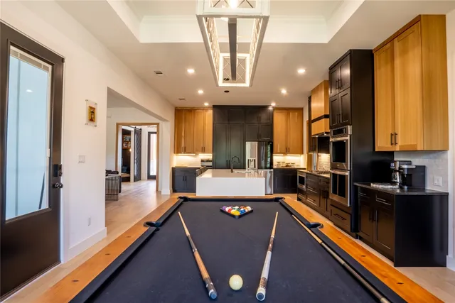 a living room with stainless steel appliances lots of white furniture and large windows