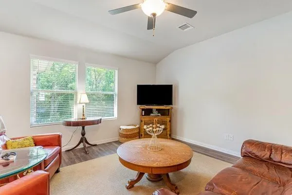 a living room with furniture a flat screen tv and a window