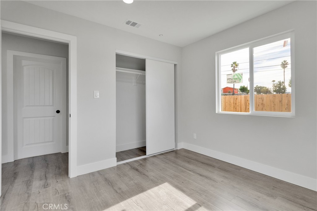 3308 Cannes Avenue Riverside, CA 92501 - Photo 23 of 38 an empty room with wooden floor and windows