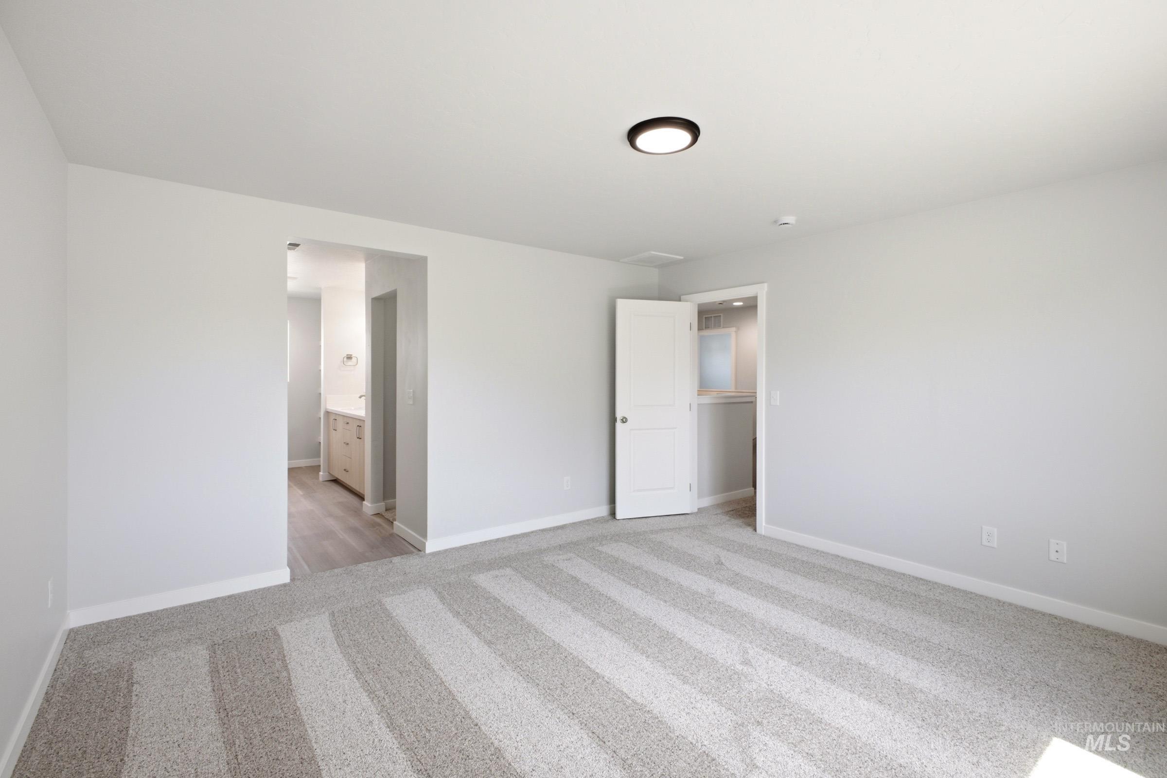 13336 Bank Street Caldwell, ID 83607 - Photo 21 of 24 Recessed ceiling light, light-toned walls, patterned carpeting, and wood-finish flooring in the adjacent area