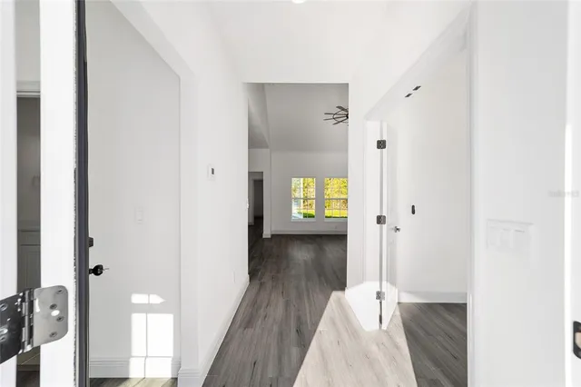 a view of a hallway with wooden floor and a living room