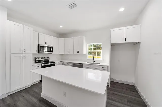 a kitchen with granite countertop white cabinets and white appliances