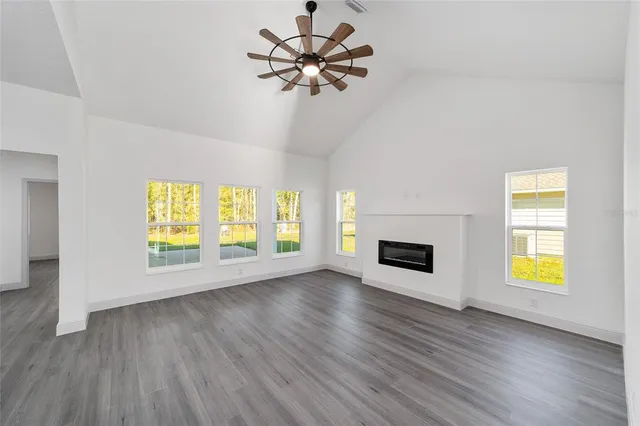 a view of a room with window a ceiling fan and wooden floor