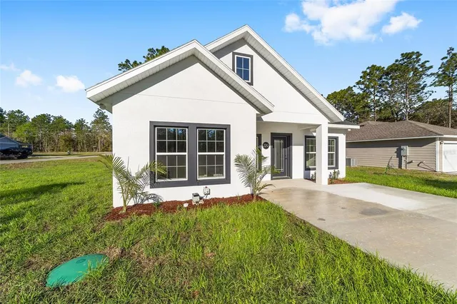 a view of a house with a yard and sitting area