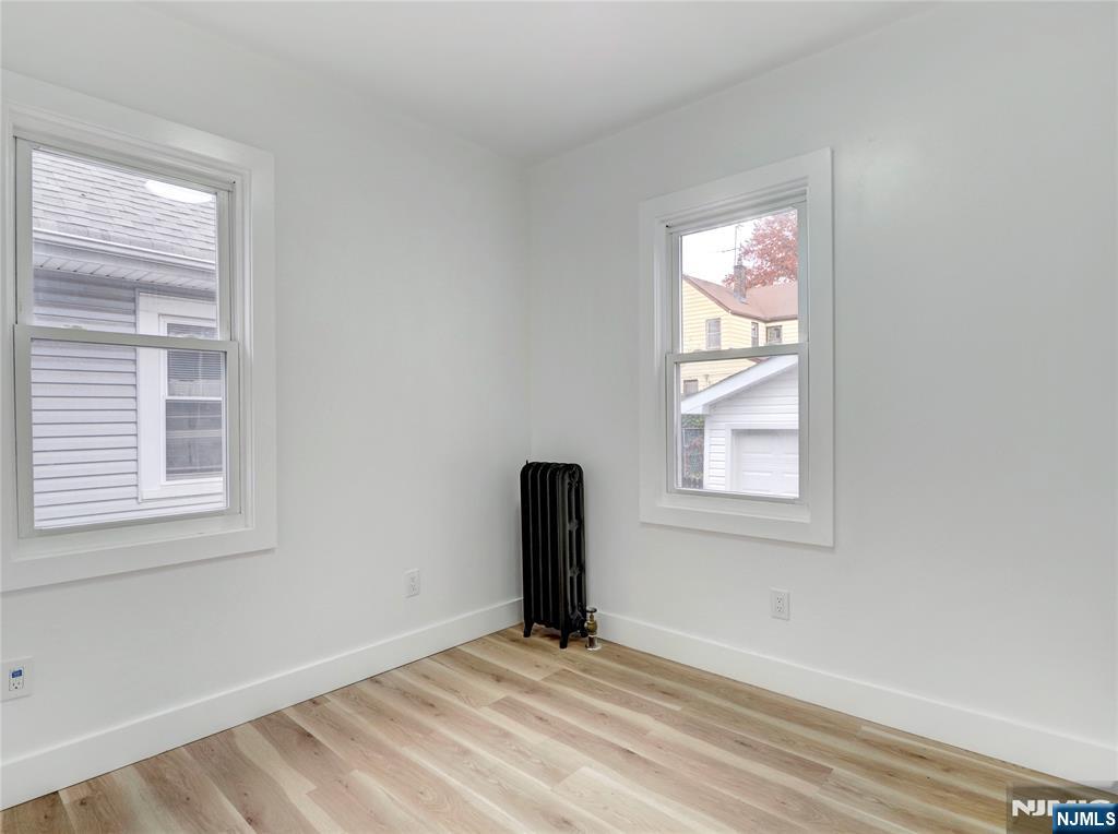 44 Laventhal Avenue Irvington, NJ 07111 - Photo 20 of 26 an empty room with wooden floor and windows