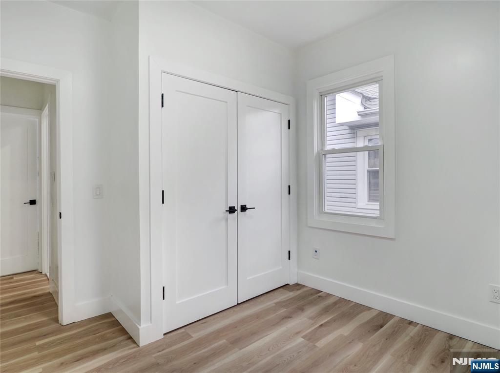 44 Laventhal Avenue Irvington, NJ 07111 - Photo 21 of 26 a view of an empty room with wooden floor and a window