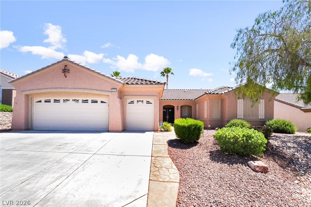 3033 Hartsville Road Henderson, NV 89052 - Photo 3 of 41 A terracotta-hued stucco residence featuring a tiled roof and dual garages for curb appeal.