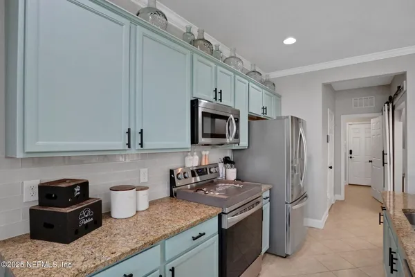 a kitchen with stainless steel appliances granite countertop a refrigerator stove and sink