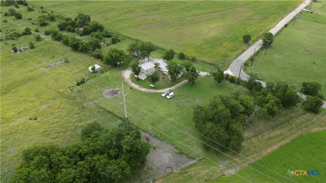 a backyard of a house with a yard and large trees