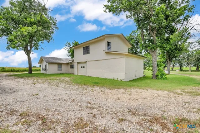 a view of a house with backyard and trees