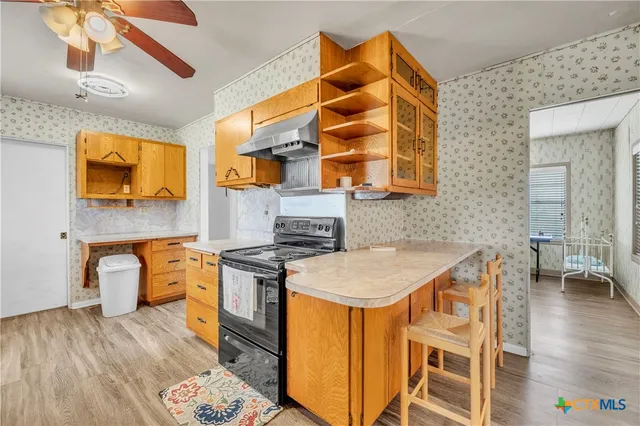 a kitchen with stainless steel appliances granite countertop a sink and wooden cabinets