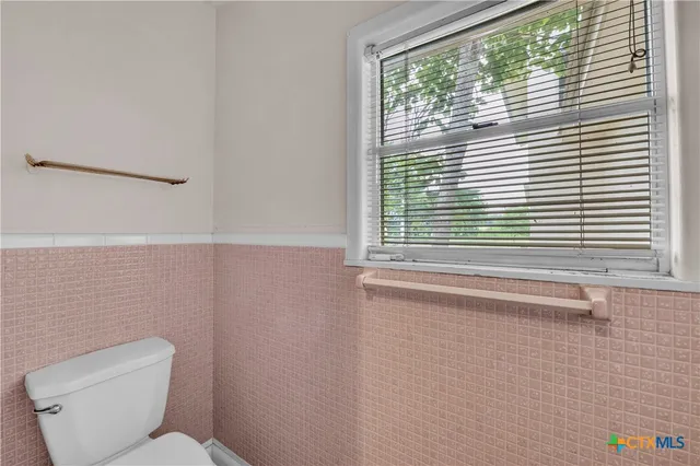 a bathroom with a toilet a sink and a window