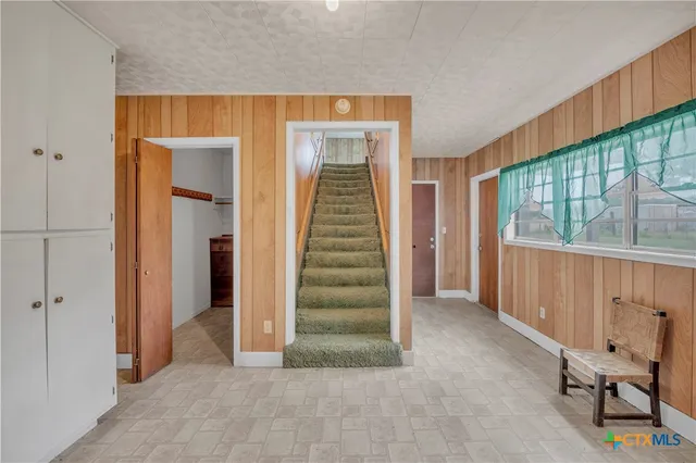 an empty room with a ceiling fan and windows