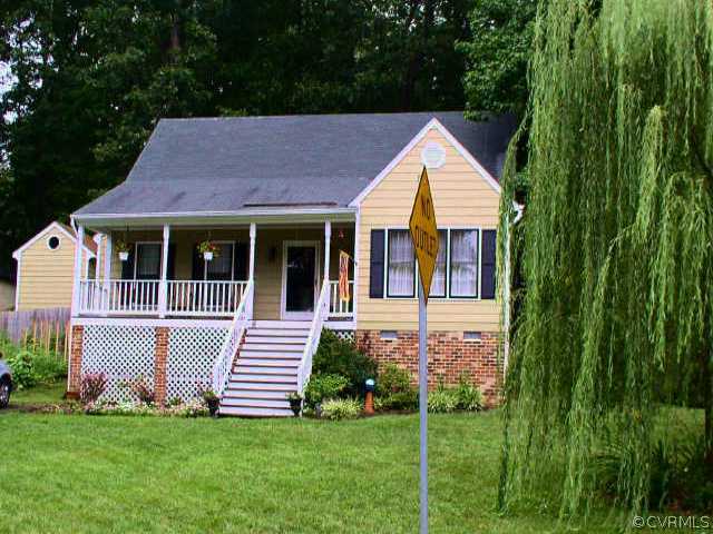 a front view of a house with a garden and yard