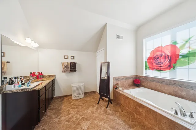 a bathroom with a granite countertop shower a sink and a mirror