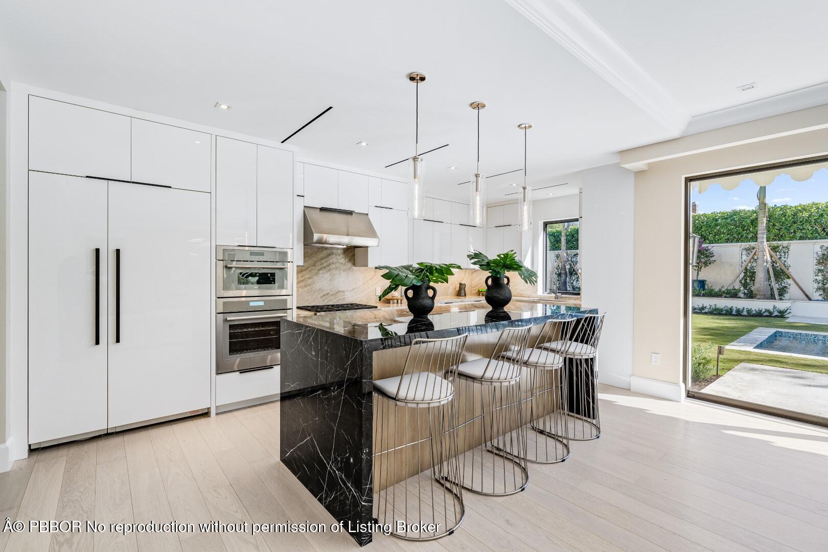 150 El Vedado Road Palm Beach, FL 33480 - Photo 17 of 77 a kitchen with stainless steel appliances kitchen island granite countertop a refrigerator a stove a sink dishwasher and white cabinets with wooden floor