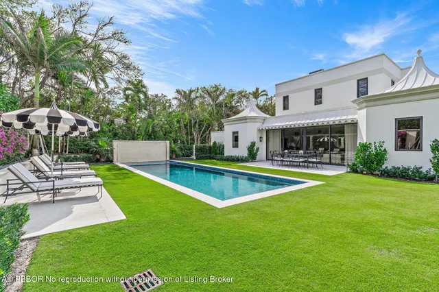 a swimming pool with outdoor seating and garden