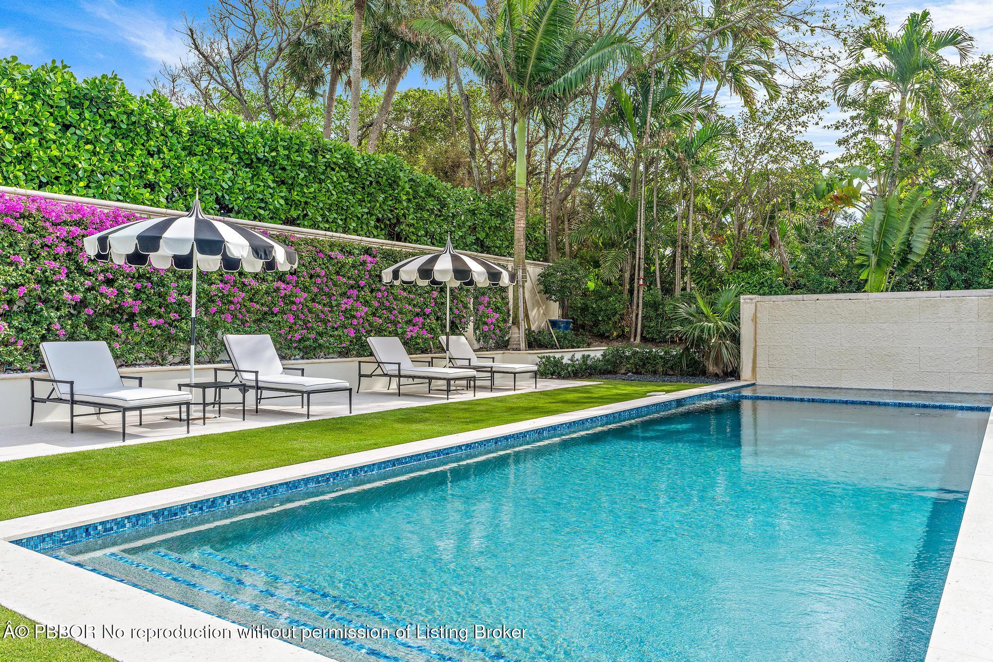 150 El Vedado Road Palm Beach, FL 33480 - Photo 51 of 77 a view of a swimming pool with a lawn chairs under an umbrella