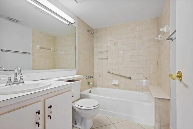 a bathroom with a granite countertop sink a toilet a mirror a bathtub and shower