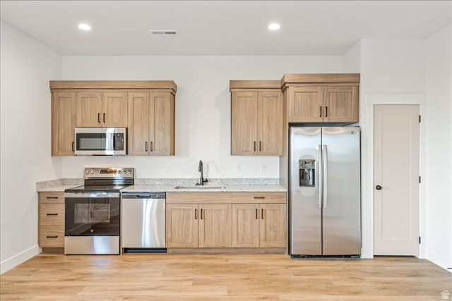 1491 East Centaurus Way, Unit 86 Washington, UT 84780 - Photo 12 of 26 Kitchen featuring stainless steel appliances, light stone countertops, light brown cabinets, light wood-style floors, and recessed lighting