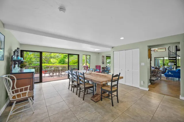 a dining room with furniture and a floor to ceiling window
