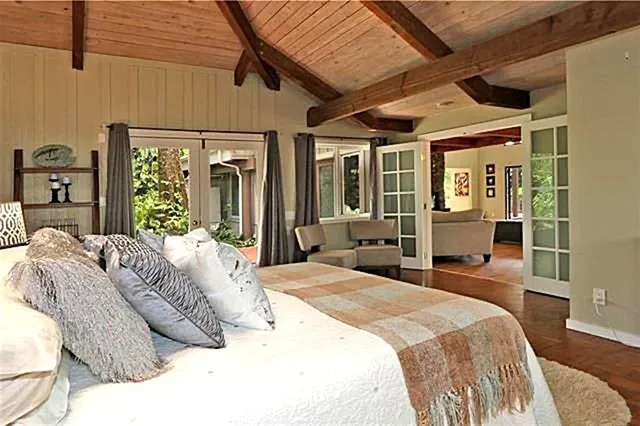 a bedroom with a large bed and wooden floor