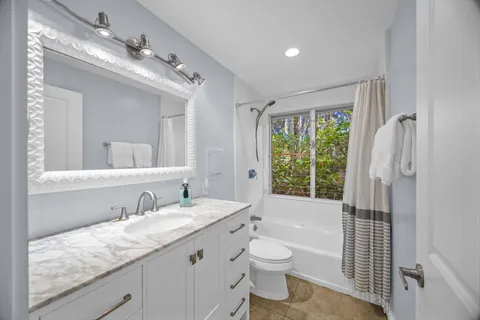 a bathroom with a granite countertop sink toilet and shower