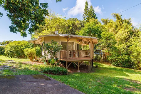 a view of a chair and table in the garden in front of a house