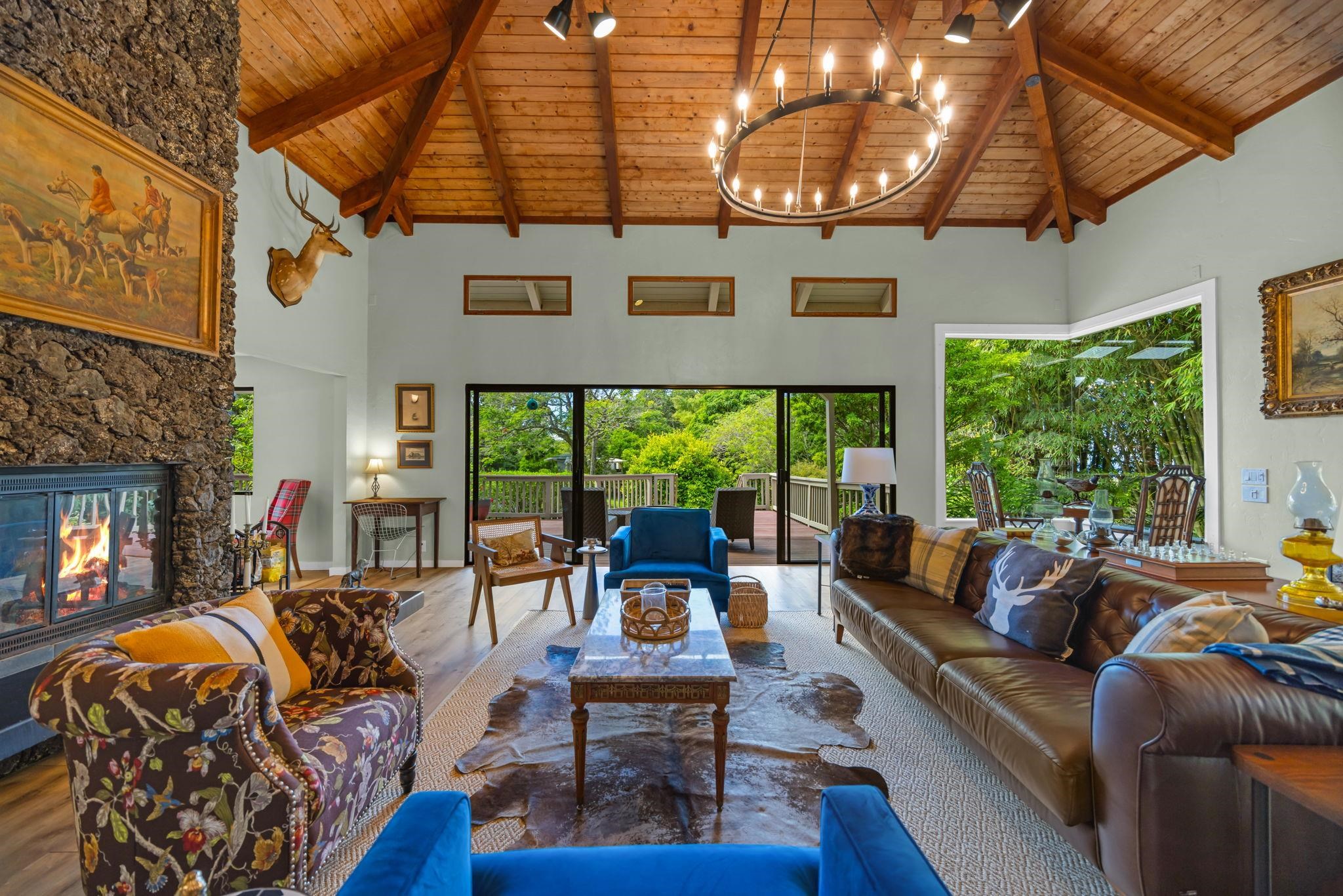 620 Awalau Road Haiku, HI 96708 - Photo 6 of 50 a living room with furniture a fireplace and floor to ceiling windows