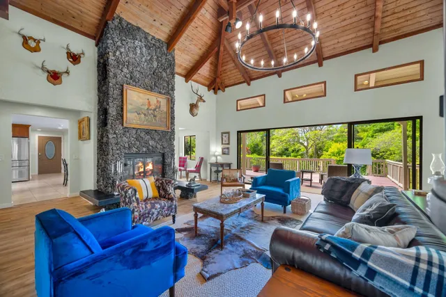 a living room with furniture a fireplace and a large window