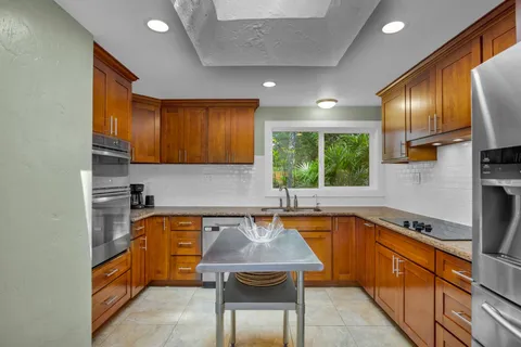 a kitchen with a sink a counter top space and stainless steel appliances
