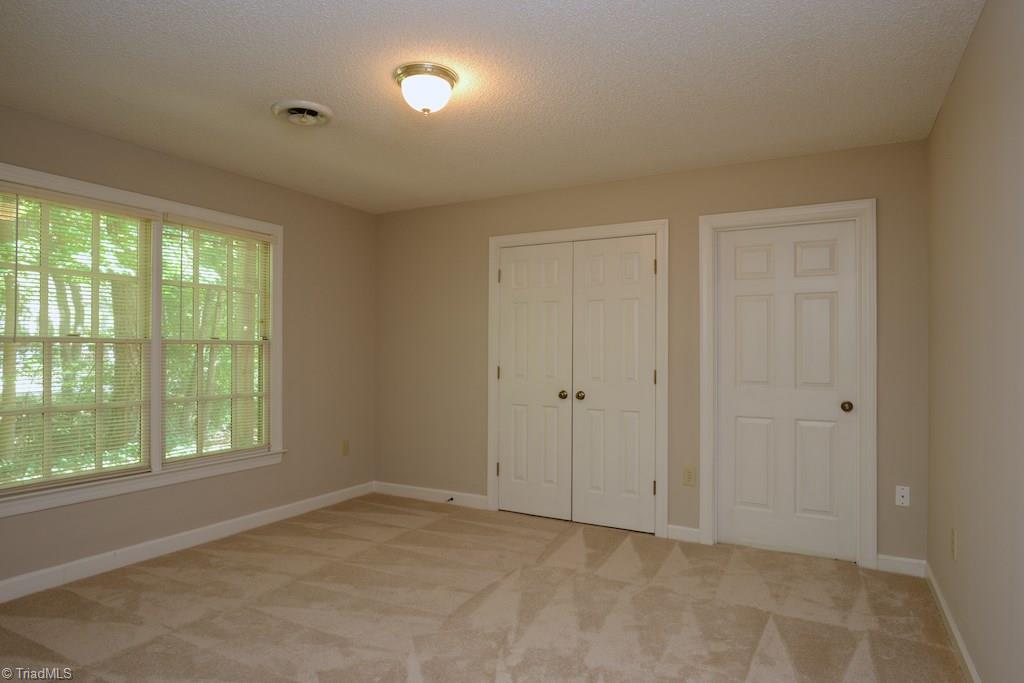 918 Flicker Lane High Point, NC 27262 - Photo 19 of 27 One of two downstairs guest rooms..both have great closets. Basement storage through door to the right