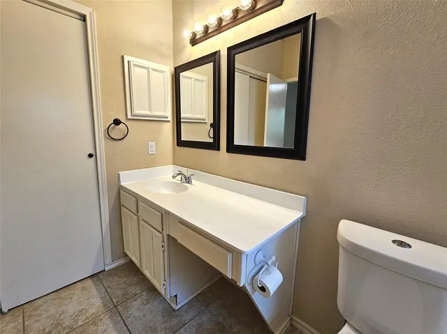 a bathroom with a sink a toilet and a mirror